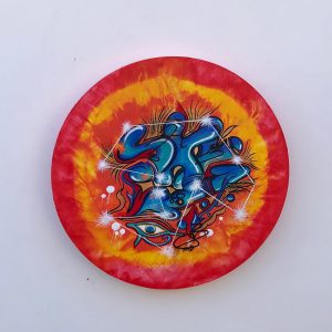 blue graffiti on circular canvas with orange and yellow background